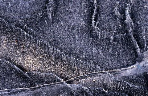 Frozen river. Sun rays on ice. Silver ice texture. Stock Photos