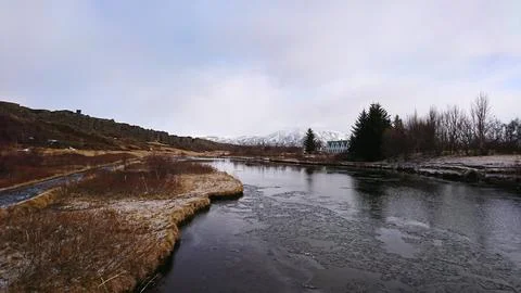 A frozen river through dried meadows in Thingvellir National Park Stock Photos