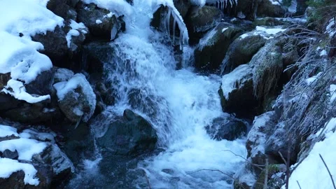 Frozen river waterfall flowing through snowy rocks slowmotion Stock-Footage 328290775