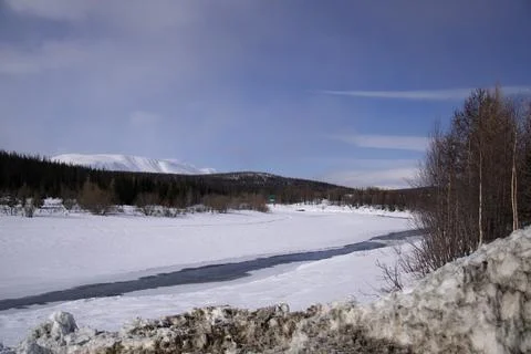 A frozen river in a winter forest Stock Photos