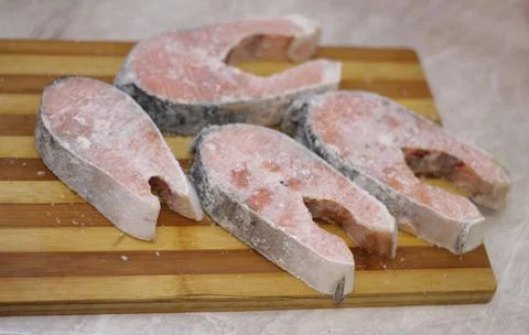 Frozen salmon raw red fish steaks on the table Stock Photos