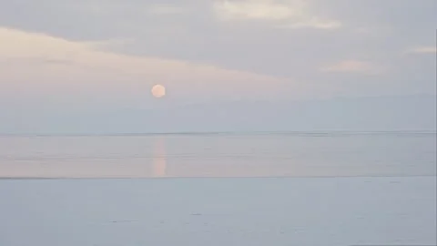 Frozen Sea with Full Moon Reflection at Sunset 스톡 동영상 326446333
