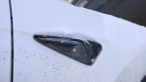 Frozen side camera on white car fender covered in winter ice and frost Stock Footage 329807063