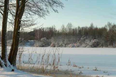 Frozen snow covered river in a winter landscape Stock Photos