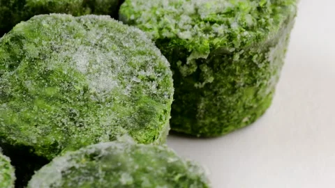 Frozen spinach blocks rotating in a circle. Close-up of icy green vegetable Stock Footage 304325083