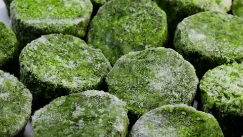 Frozen spinach blocks rotating in a circle. Close-up of icy green vegetable Stock Footage 304325849