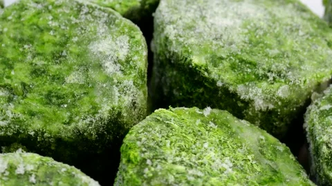 Frozen spinach briquettes rotating in circle, close-up view of green vegetable Stock Footage 304324606
