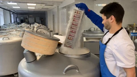 Frozen stem cells in test tubes are removed from the container with nitrogen Stock Footage 123442650