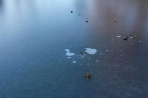 Frozen surface with debris forms patterns in a tranquil outdoor setting Stock Photos