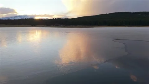 Frozen surface of Laguna La Zeta reflecting sunset colors near Esquel Argentina Stock Footage 337933633