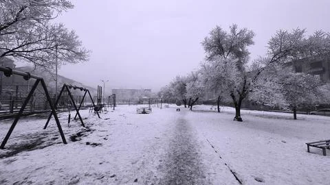 Frozen swing on an abandoned and haunted playground in winter Stock Photos