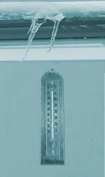 Frozen thermometer over a wall, under ice and snow Stock Photos