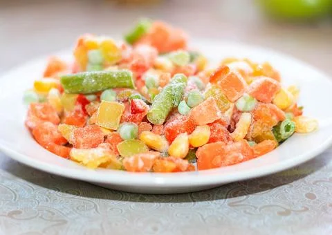 Frozen vegetable mixture in a plate on the table. Blurry. Foto stock