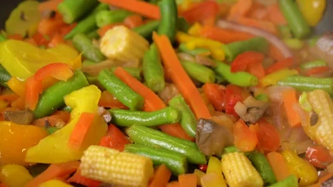 Frozen vegetables cooked in frying pan, steam rises, close-up 库存影片 234459656