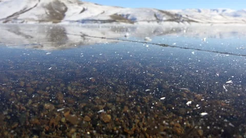 Frozen water surface holds ice sheets and cracks, winter stream - Ice Formation Stock Footage 339817813