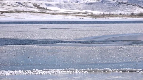 Frozen water surface holds ice sheets and cracks, winter stream - Glassy Ice Stock Footage 339817921