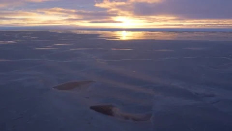 Frozen water surface in rays of sun. Waves on purple ice. View from ship. Lilac Stock Footage 218588630