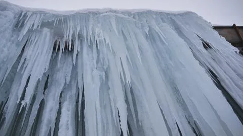 Frozen waterfall creating a wall of sharp icicles in a winter landscape Stock Photos
