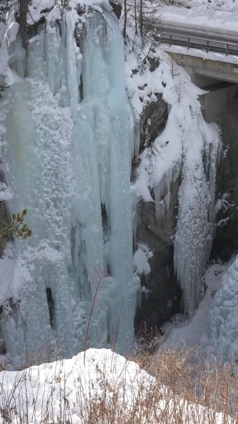 Frozen waterfall with icicles in snowy mountain forest in pontresina switzerland 스톡 동영상 329555120