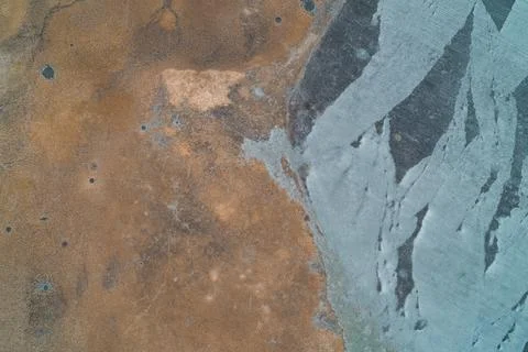 Frozen wetland landscape split between dry orange reeds and blue ice sheet with Stock Photos