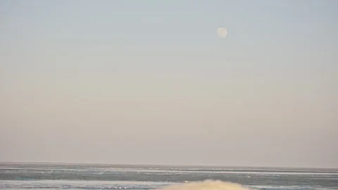 Frozen White Sea Under Orange and Blue Sky with Full Moon 스톡 동영상 326436635