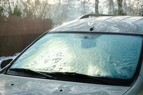 The frozen window of a car in cold winter day. Frost pattern. Selective focus Stock-Fotos
