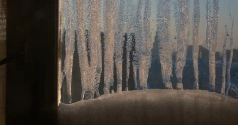 Frozen window, ice crystals and frost pattern at sunrise, blurred city Stock Footage 347671851
