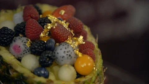 Fruit and berry dessert: in the pineapple are strawberries, raspberries, blueber Stock Footage 107650168