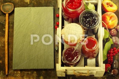 Fruit and berry jam on a rustic background Stock Photos