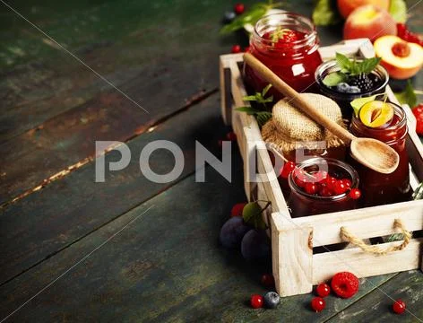 Fruit and berry jam on a wooden background Stock Photos
