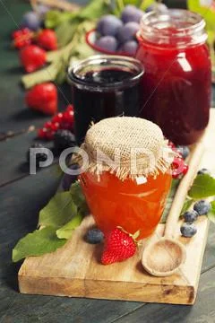 Fruit and berry jam on a wooden background Stock Photos