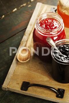 Fruit and berry jam on a wooden background Stock Photos