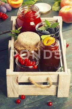 Fruit and berry jam on a wooden background Stock Photos