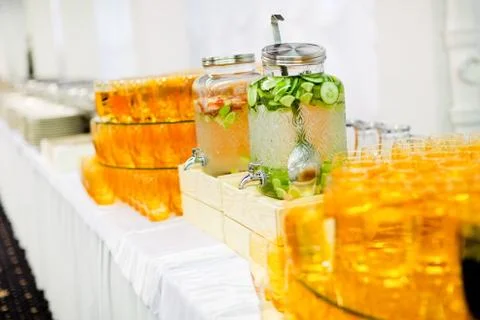 Fruit and vegetable drinks in big glass beverages dispensers Stock Photos