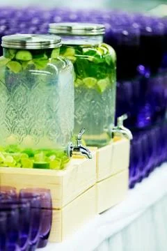 Fruit and vegetable drinks in big glass beverages dispensers Stock Photos