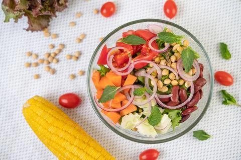 Fruit and vegetable salad in a glass cup on a white ground Stock Photos