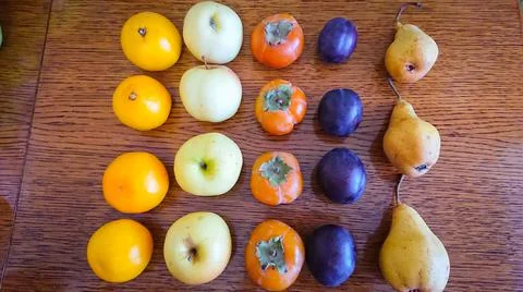 Fruit background. Apples, oranges, pears, persimmons, plums. Stock Photos
