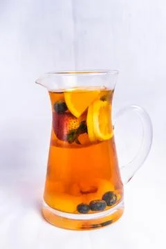 Fruit black tea include lemon slice, strawberry and blueberry served in jar.. Stock Photos