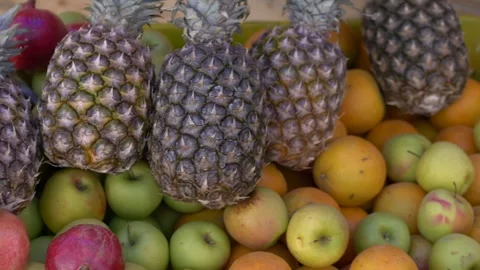 Fruit box filled with pineapples and apples at open market, natural textures and Stock Footage 321818190