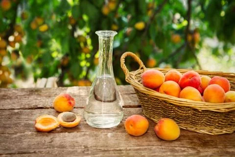 Fruit brandy in a bottle and fresh apricots Stock Photos