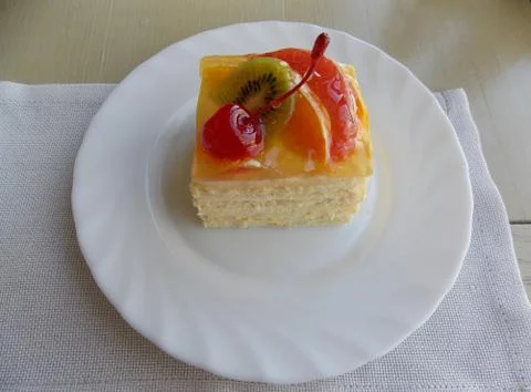 Fruit cake with a cherry on a plate Stock Photos