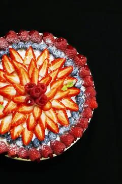 Fruit cake decorated with assorted mixed berries with black background Stock Photos
