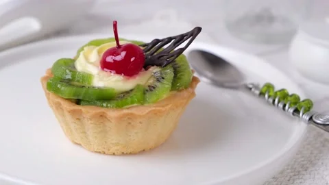 Fruit cake or dessert tartlet with kiwi cream cheese and dessert cherries Stock Footage 166468427