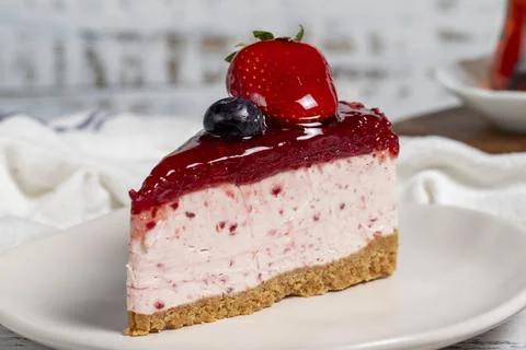 Fruit cake slice. Cheesecake slice with blackberry sauce on wood background.  Stock Photos