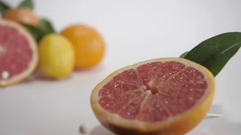Fruit composition. Little mints falls on grapefruit in slow motion Stock Footage 156512856