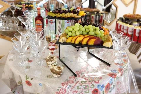 Fruit display with grapes, peaches, pears and cherries beside Martini bottles Stock Photos