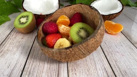 Fruit falling on an empty coconut. Slow motion. Stock Footage 130350528
