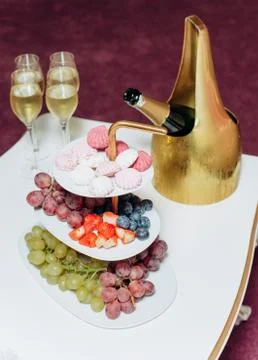 Fruit grapes marshmallows colored table set champagne Foto stock