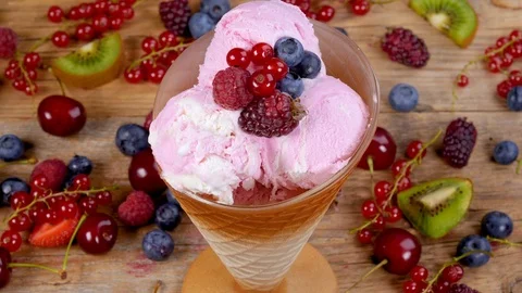 Fruit ice cream in cup rotating on table full of forest fruits Stock Footage 91490562