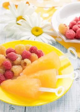 Fruit ice cream yellow raspberry with mixed berries raspberries on a plate on Stock Photos